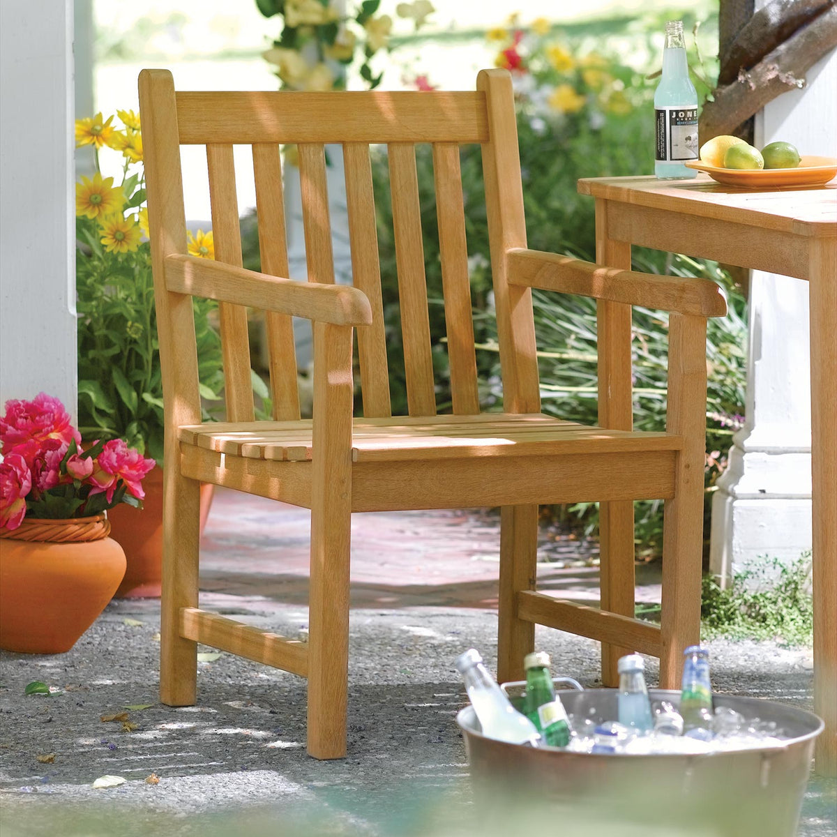 Teak dining armchairs set on a garden terrace