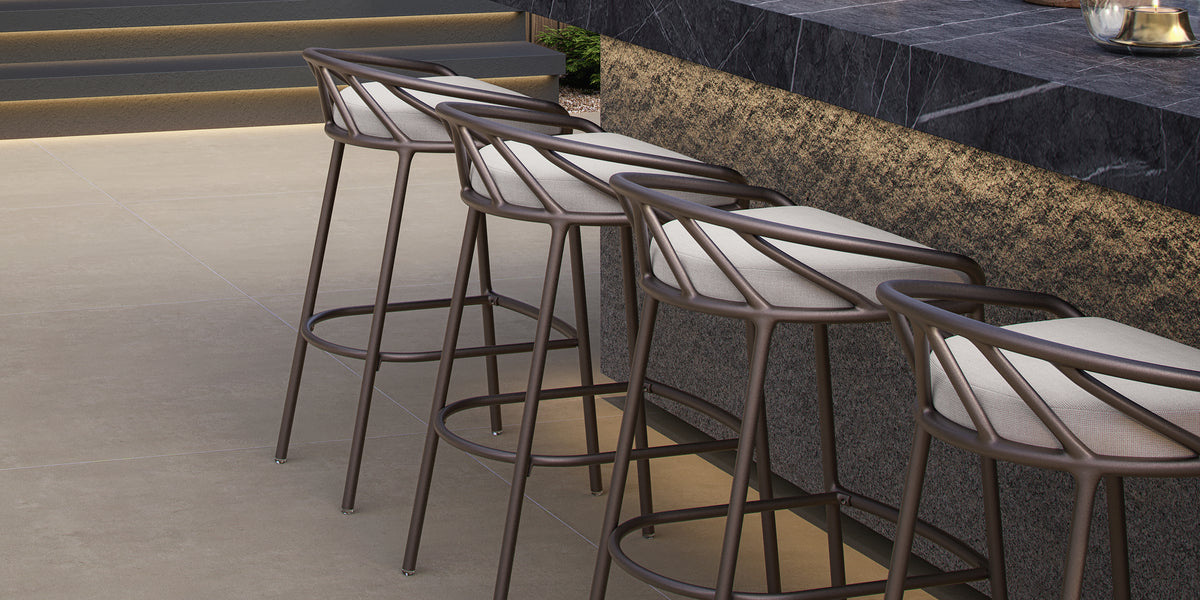 Seavo bar stools with Sunbrella seat pads lined up along an outdoor bar