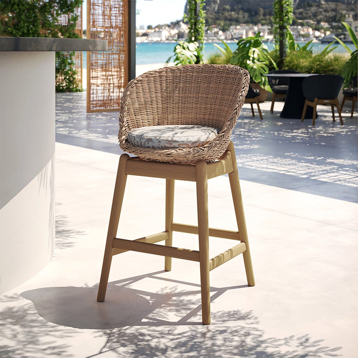 Woven bar stool photographed from the front at an angle showing the woven footrest