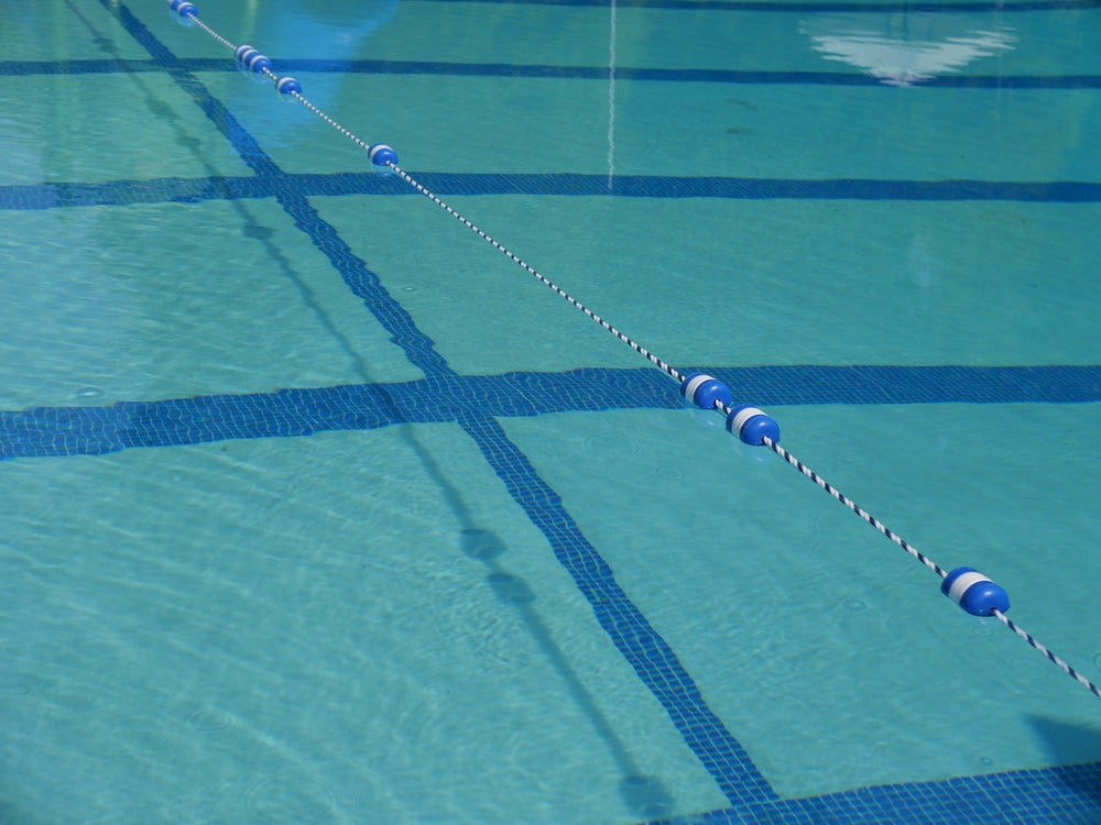 A lane rope stretched across clear pool water
