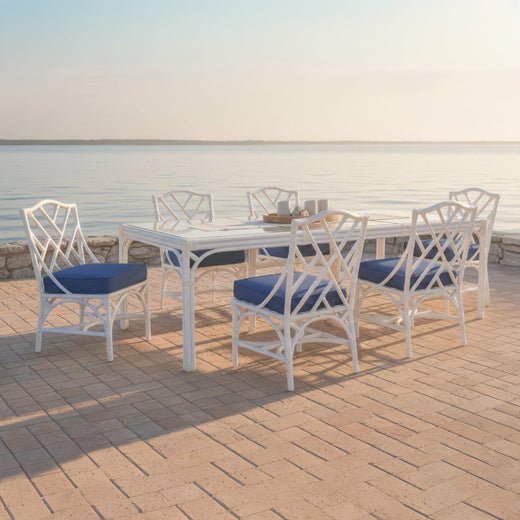 The Chippendale dining set laid for dinner on a waterfront deck at sunset