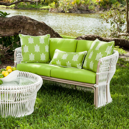 Fiji woven loveseat in Sunbrella Macaw on a lawn