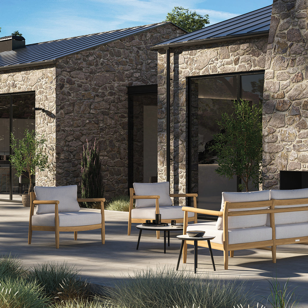 Full Lido teak collection arranged as an outdoor lounge group on a terrace, sofa with loveseat and club chairs