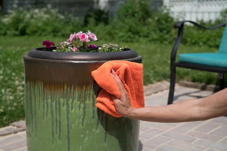 Wiping a planter clean with an orange cloth