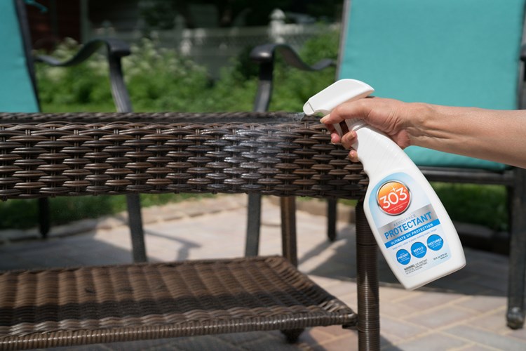 Spraying 303 Aerospace Protectant onto a wicker patio table