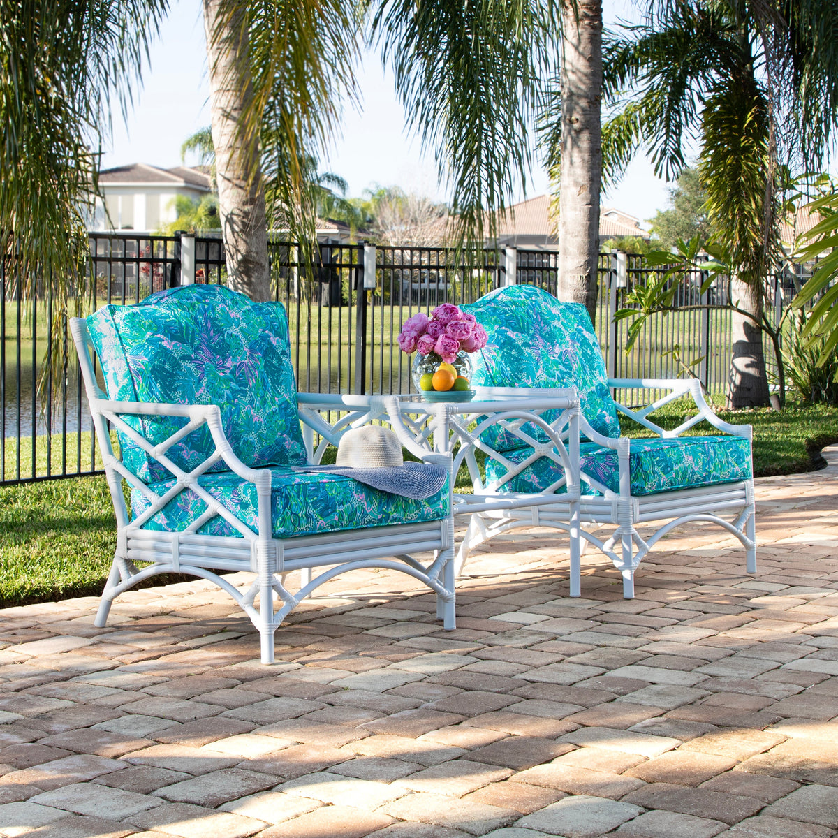 Chippendale outdoor lounge chairs and an end table from the terrace set, beside a pool