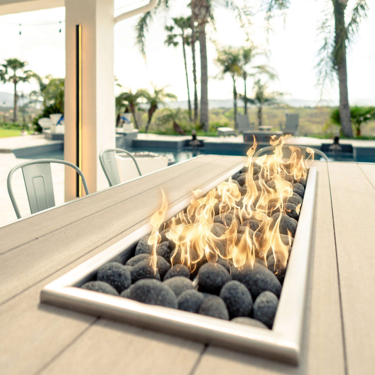 The Outdoor Plus Alameda linear fire table running along a covered outdoor room