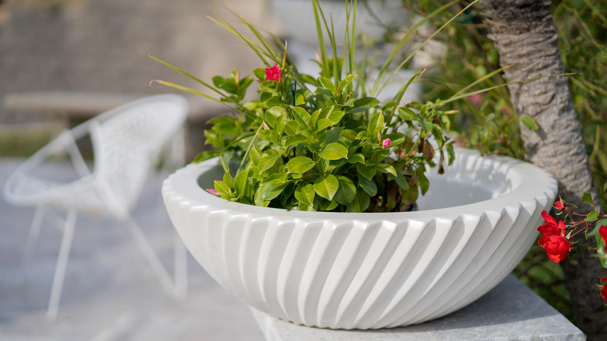 The Outdoor Plus Sedona planter bowl planted with flowers and trailing greenery