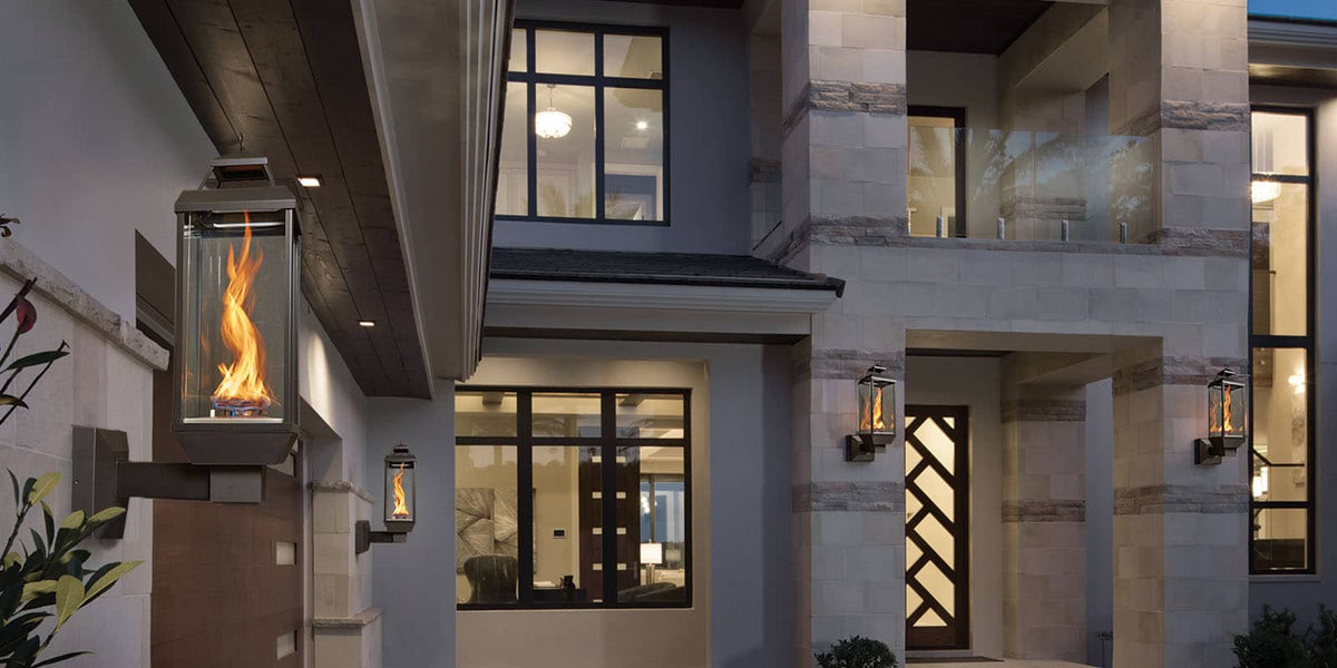 FireGarden Tempest Lantern lit on an exterior wall mount