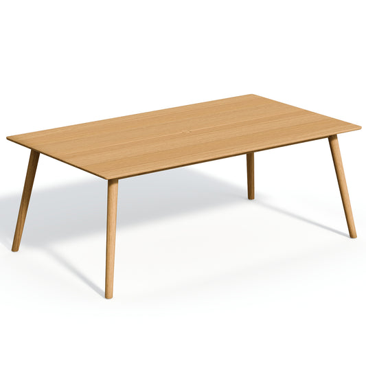 Long rectangular solid teak dining table with a center umbrella hole, on a plain white background
