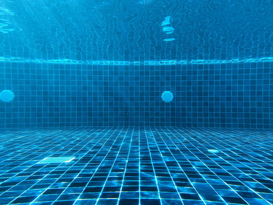Underwater view of a blue tiled pool with return fittings