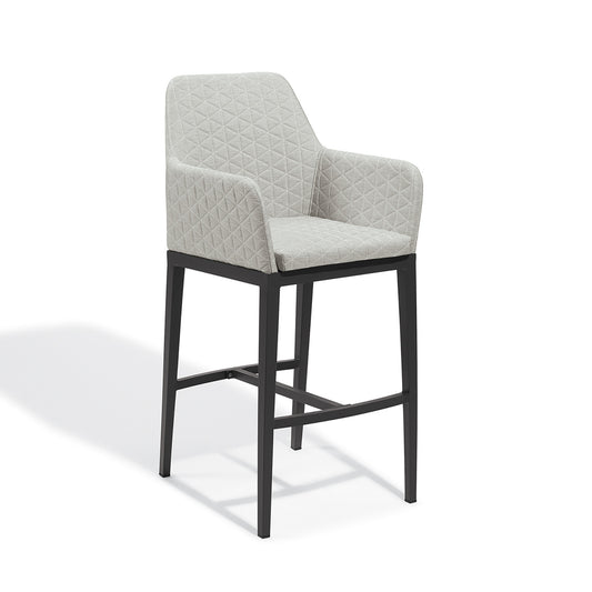 Quilted upholstered bar height chair in Canvas Granite on a Carbon powder coated aluminum frame, photographed on a plain white background