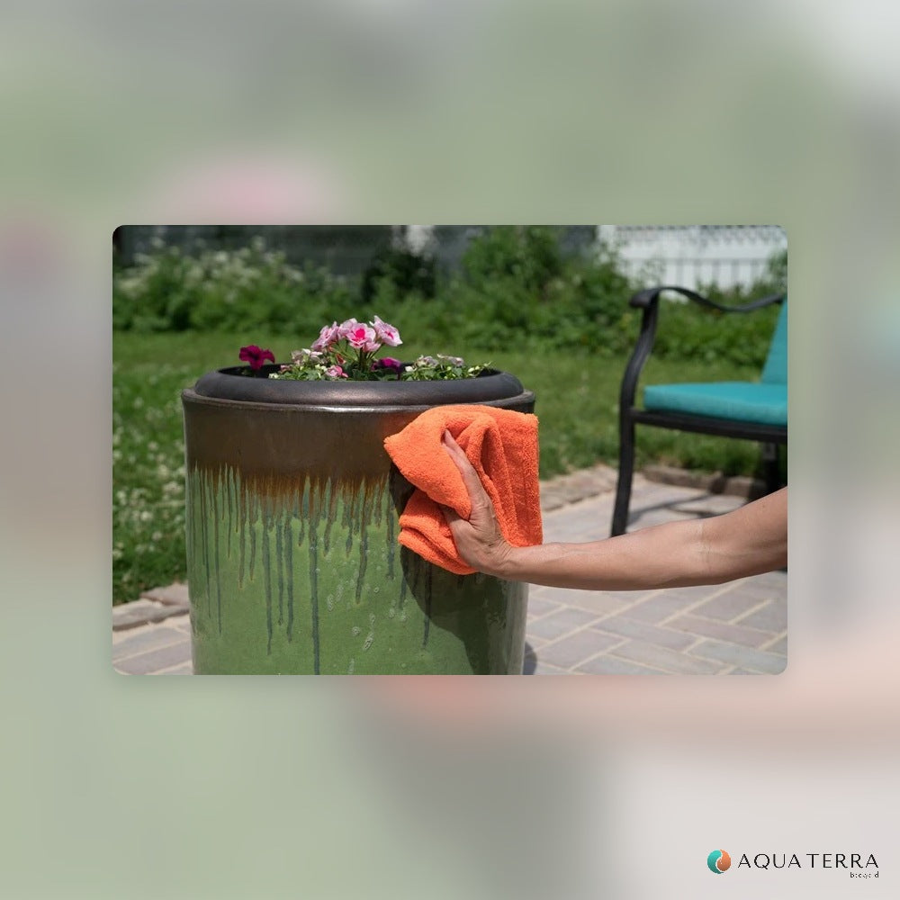 Wiping a glazed outdoor planter clean with an orange cloth after spraying 303 Multi-Surface Cleaner